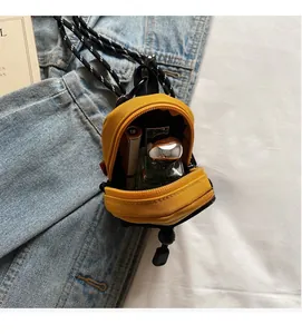 Detailed top view of a yellow mini nylon crossbody bag holding lipstick and perfume