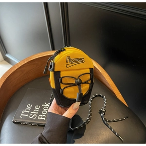 Detail view of mini nylon crossbody bag with yellow and black contrast and rope strap