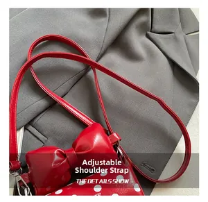 Detailed view of adjustable shoulder strap and silver metal clasp on polka dot bow bag