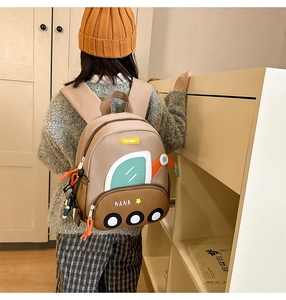 Rear view of a child wearing the cute cartoon vehicle backpack with 3D wheel details
