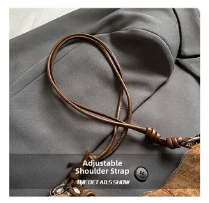 Detail of adjustable brown leather strap with knot and metal hook for croissant bag
