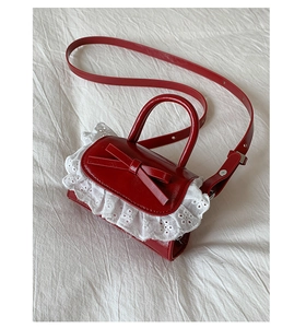 Macro detail of red mini PU bag featuring a glossy finish and intricate white lace trim