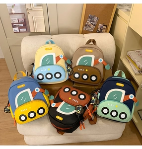 Detail of cartoon car-shaped children backpacks in multiple vibrant colors with charms