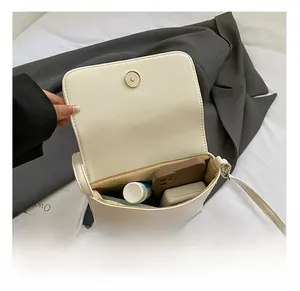 Interior view showing the capacity of white leather crossbody bag with items