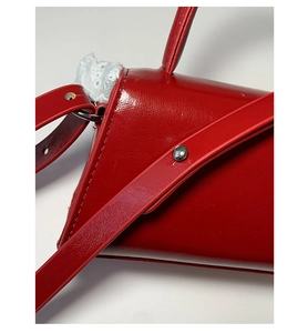 Detailed macro view of red glossy PU leather surface with white lace trim and silver studs