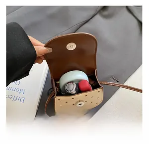 Détail de l'intérieur du mini sac bandoulière à pois avec maquillage et rouge à lèvres