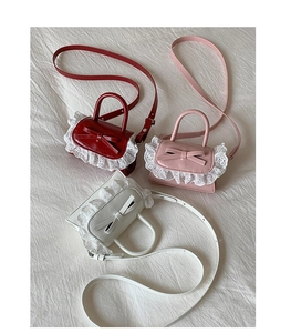 Detailed view of mini PU leather crossbody bags with lace trim and bow in red, pink, and white
