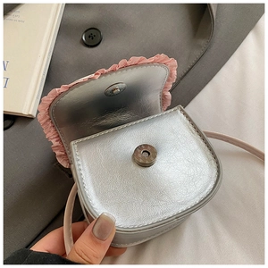 Detail of silver metallic mini bag showing pink lace trim and magnetic snap closure