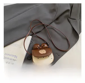 Détail d'un sac bandoulière enfant en forme de pomme avec pois et nœud élégant