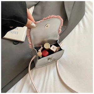 Internal view of silver mini crossbody bag showing storage capacity for cosmetics