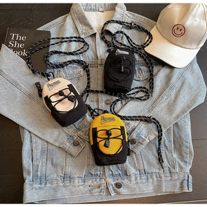 Lifestyle shot of trendy mini crossbody bags in ivory, yellow, and black on denim fabric