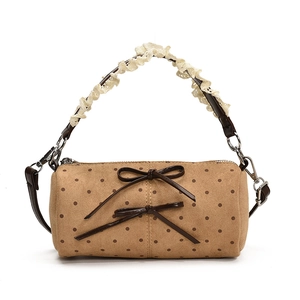 Bolso cilíndrico de lunares con asa de encaje y lazos decorativos estilo retro