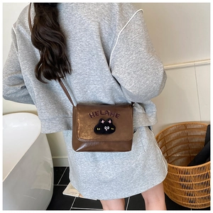 Detailed view of the brown cat patch crossbody bag on a child model back profile