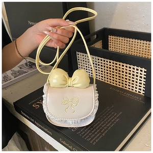 Detail of cute cream crossbody bag with yellow bow, lace trim and floral embroidery
