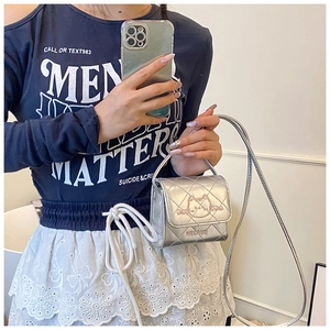 Close-up of a silver quilted mini bag with a pink cat motif and shiny finish