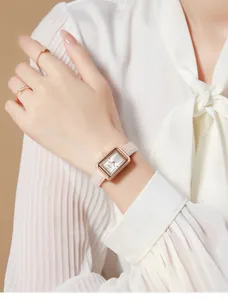 Elegante roségoldene rechteckige Uhr mit beigem Lederarmband am Handgelenk