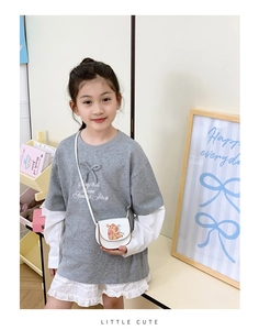 Détail d'un sac cartable blanc Capybara pour enfant avec des bords marrons et motifs