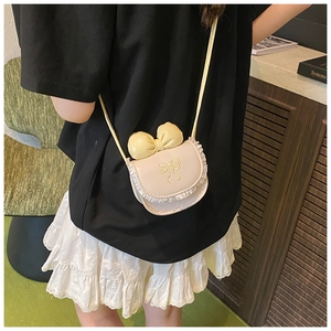 Close-up of sweet pink girls' shoulder bag with yellow bow and white lace trim detail