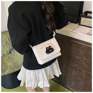 Detailed close-up of white cat cross body bag featuring pink embroidery and a flap closure