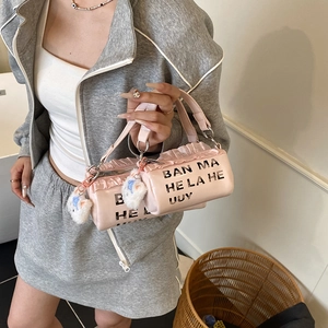 Pink cylinder kid handbag with ruffle trim, letter print and cat plush pendant