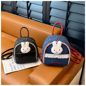 Close-up of denim mini backpacks featuring plush bunny icons and lace trim details