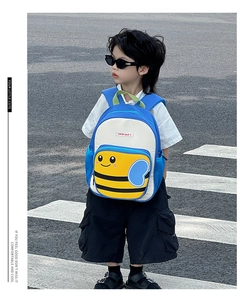 Outdoor shot of a boy wearing a blue and white cartoon bee toddler backpack