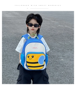 Close-up of cute cartoon bee design on blue and white kids backpack worn by child