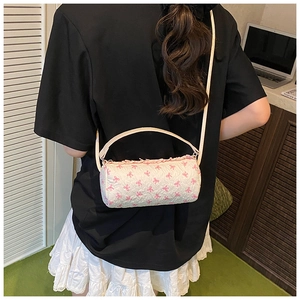 Detail of white cylinder shoulder bag with pink bow pattern and ruffled top edges
