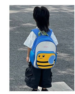 Rear view of a blue and white cartoon bee backpack for children on a casual outdoor street