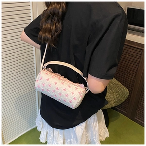 Close-up of white cylindrical bag with pink bow pattern and seersucker fabric texture