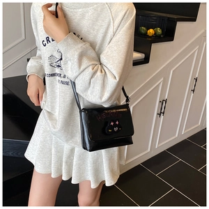 Detail of cute black cartoon cat crossbody bag with HELLANE embroidery for kids