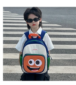 Outdoor shot of a colorful patchwork kids backpack with cute smiling cartoon face