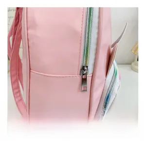 Detailed shot of smooth rainbow-colored metal zipper on pink PU leather backpack