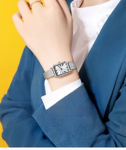 Détail de la montre à bracelet tissé argenté avec chiffres romains et cadran ondulé
