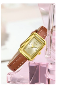 Detail einer Vintage-Quarzuhr in Gold mit Champagner-Zifferblatt und braunem Lederband