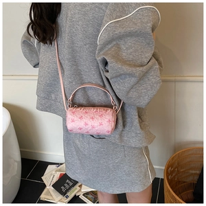 Detail of pink cylindrical handbag with 3D floral embroidery and leather handles