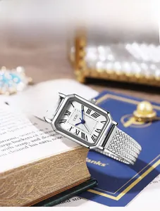 Détail d'une montre carrée argentée vintage avec cadran à vagues et bracelet en maille