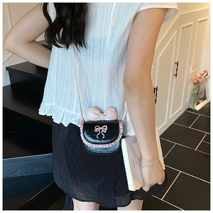 Detail of mini black crossbody bag for girls with pink bow and lace trim decoration