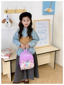 Close-up of kids purple unicorn backpack with embroidery and iridescent rainbow pocket