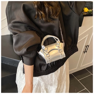 Close-up of mini silver metallic handbag with mirror finish and elegant chain strap
