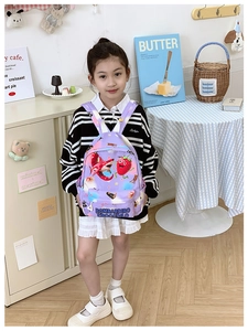 Detail of purple cartoon kids backpack with waterproof nylon fabric and strawberry prints