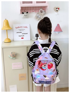 Detail of purple cartoon backpack with shark prints worn by a child in a cozy room
