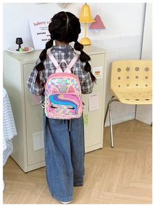 Detail eines rosa Einhorn-Rucksacks für Kleinkinder mit bunten Pailletten und 3D-Ohren
