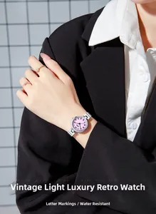 Détail d'une montre bracelet en alliage argenté avec cadran rose portée par un mannequin
