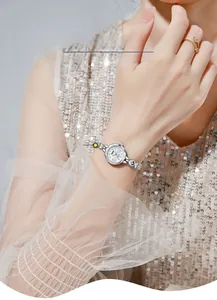 Gros plan d'une élégante montre-bracelet argentée avec cadran en nacre au poignet