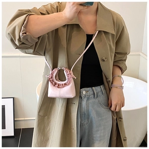 Close-up of pink mini crossbody bag with gingham ruffle trim on a model outfit