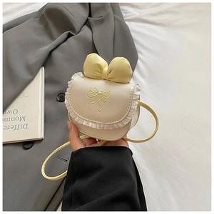 Detail of girls' cream crossbody bag with lace trim and large yellow bow accessory
