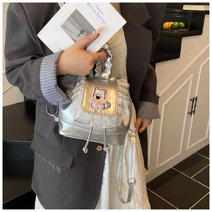 Detail of silver metallic mini backpack featuring lace trim and cute cartoon dog patch