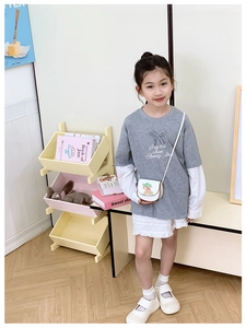 Détail du t-shirt gris à manches longues pour enfant et jupe plissée blanche élégante