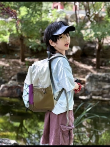 Detail view of a lightweight multi-color patchwork backpack on a child in outdoor park